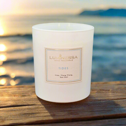 Luminessa candle labeled 'Tides' on a wooden surface with a blurred natural background