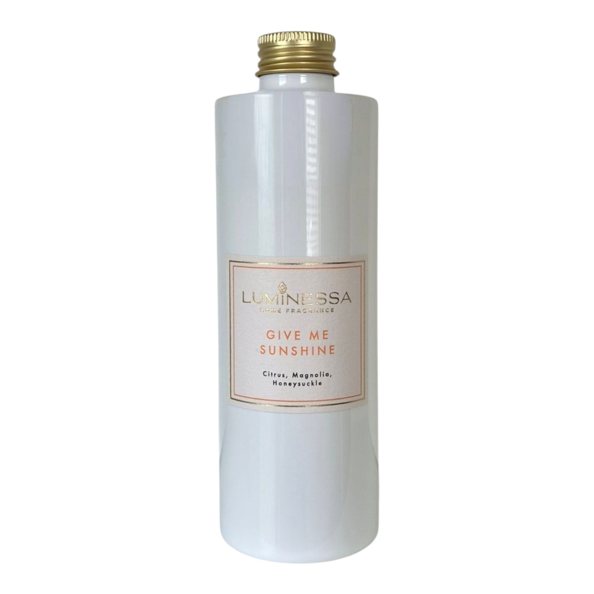 A tall, cylindrical white bottle with a gold screw cap and a central cream-colored label reading 'LUMINESSA' and 'GIVE ME SUNSHINE'.